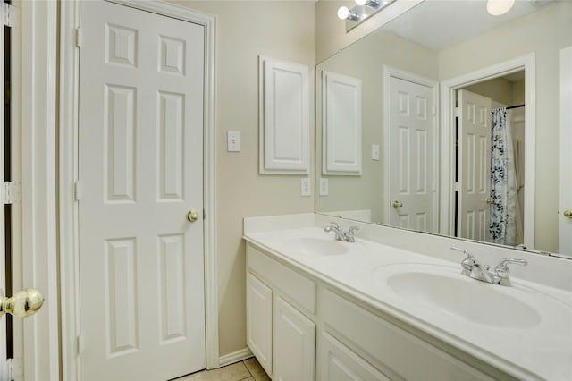 full bathroom featuring double vanity, a sink, baseboards, and tile patterned flooring