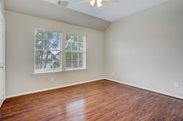 spare room with a ceiling fan, baseboards, wood finished floors, vaulted ceiling, and visible vents