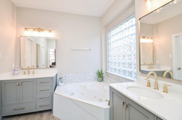 15027 Wildberry Creek Ct, Cypress, TX 77433 - bathroom with a sink, a tub with jets, wood finished floors, and two vanities
