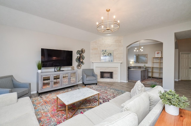 15027 Wildberry Creek Ct, Cypress, TX 77433 - living room featuring an inviting chandelier, arched walkways, a large fireplace, wood finished floors, and lofted ceiling