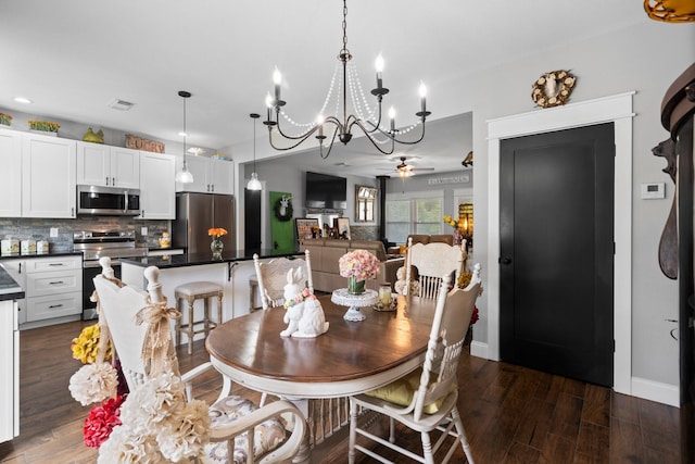dining area with baseboards, visible vents, ceiling fan with notable chandelier, and dark wood-type flooring
