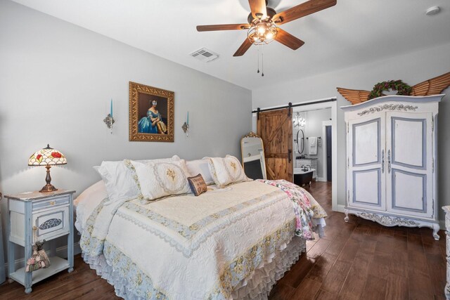 bedroom featuring ceiling fan, visible vents, a barn door, and dark wood-type flooring