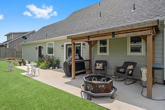 rear view of house featuring a patio, fence, a shingled roof, and an outdoor fire pit
