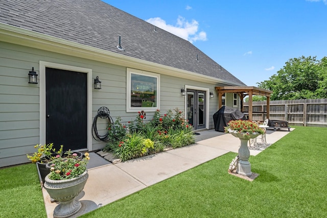 back of house featuring a yard, a patio, fence, and roof with shingles