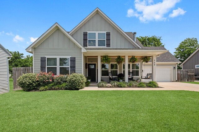 view of front of property featuring board and batten siding, fence, covered porch, and concrete driveway