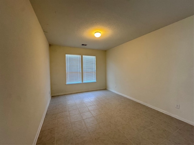 8011 Cheyenne Hills Trl, Richmond, TX 77406 - empty room with baseboards, tile patterned flooring, a textured ceiling, and visible vents