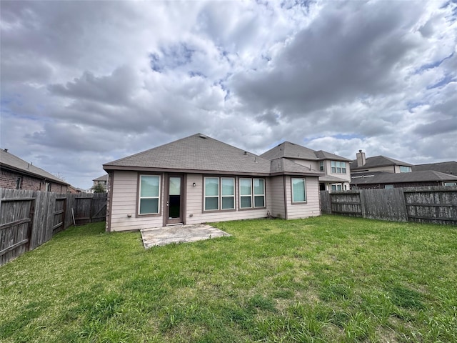 8011 Cheyenne Hills Trl, Richmond, TX 77406 - back of house featuring a lawn, a shingled roof, a fenced backyard, and a patio area