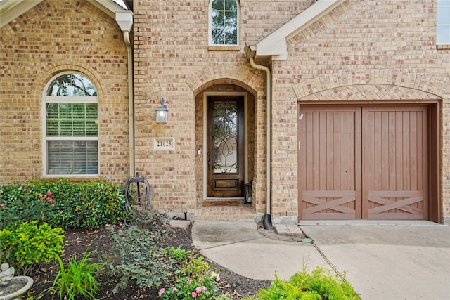21023 Barrett Woods Dr, Richmond, TX 77407 - property entrance with concrete driveway, brick siding, and a garage
