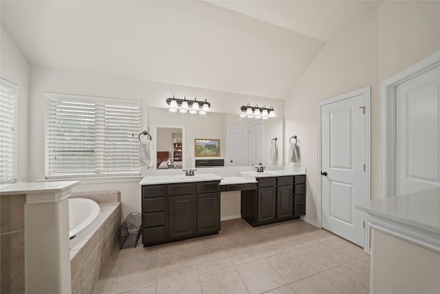 21023 Barrett Woods Dr, Richmond, TX 77407 - bathroom featuring a garden tub, lofted ceiling, tile patterned floors, two vanities, and a sink