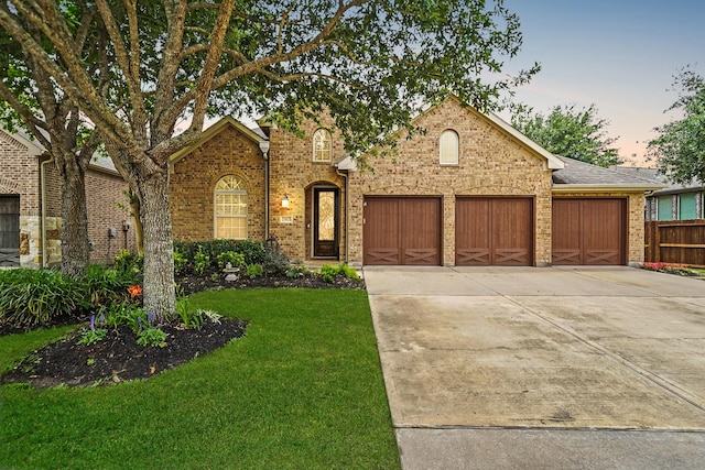 21023 Barrett Woods Dr, Richmond, TX 77407 - view of front of property featuring fence, an attached garage, brick siding, concrete driveway, and a lawn