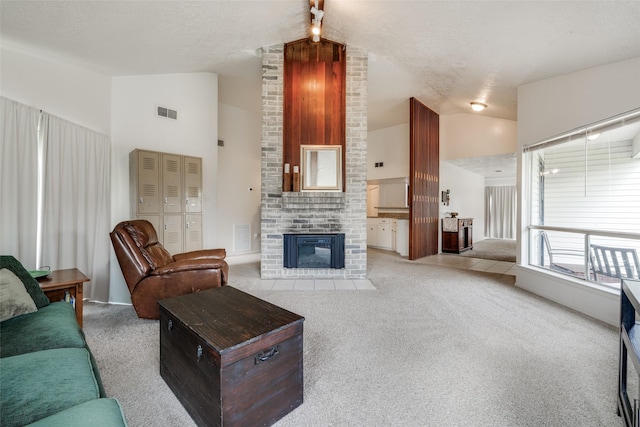 living area with carpet floors, a brick fireplace, visible vents, and high vaulted ceiling