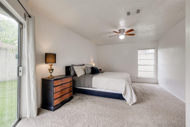 bedroom featuring a ceiling fan, visible vents, baseboards, access to outside, and light carpet