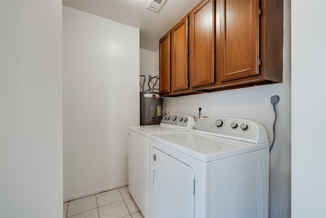 clothes washing area with visible vents, light tile patterned flooring, washer and clothes dryer, electric water heater, and cabinet space