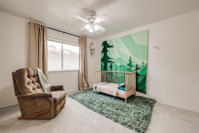 living area featuring baseboards, a textured ceiling, carpet, and ceiling fan