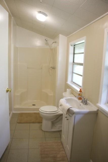 full bath with vanity, tile patterned floors, a shower stall, and toilet