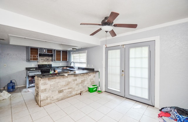kitchen with a ceiling fan, french doors, black electric range oven, a sink, and a peninsula