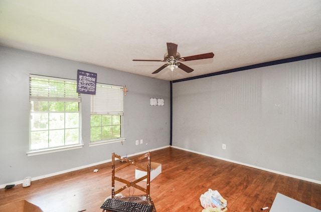 spare room featuring baseboards, a ceiling fan, and wood finished floors