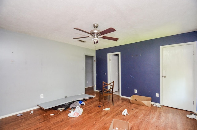 spare room featuring a ceiling fan, baseboards, visible vents, and wood finished floors