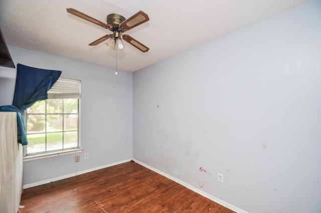 unfurnished room with baseboards, ceiling fan, and wood finished floors