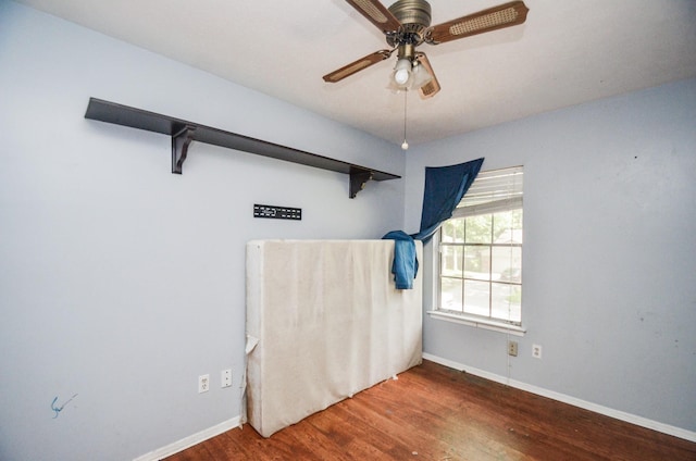 unfurnished room featuring baseboards, a ceiling fan, and wood finished floors
