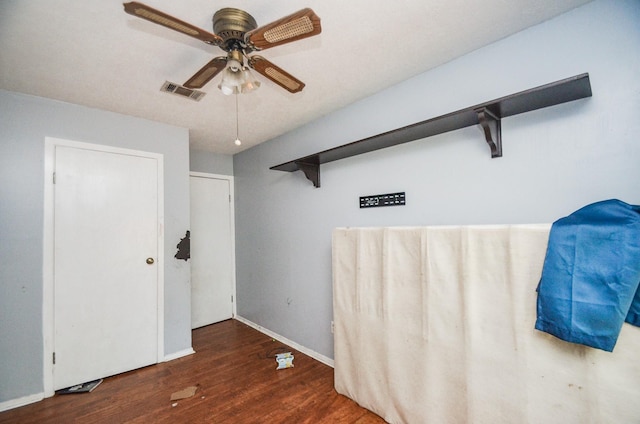unfurnished bedroom featuring ceiling fan, baseboards, visible vents, and wood finished floors