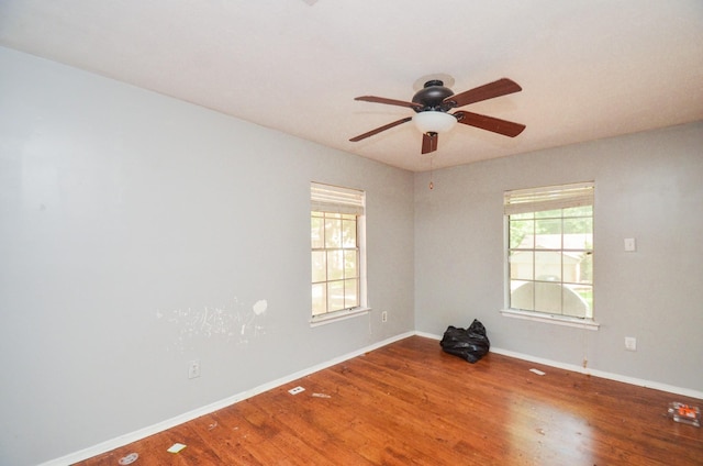 empty room with baseboards, ceiling fan, and wood finished floors