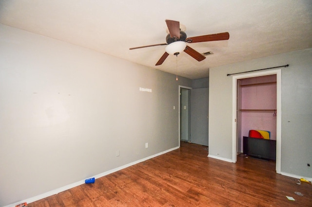 unfurnished bedroom with visible vents, baseboards, wood finished floors, and a closet