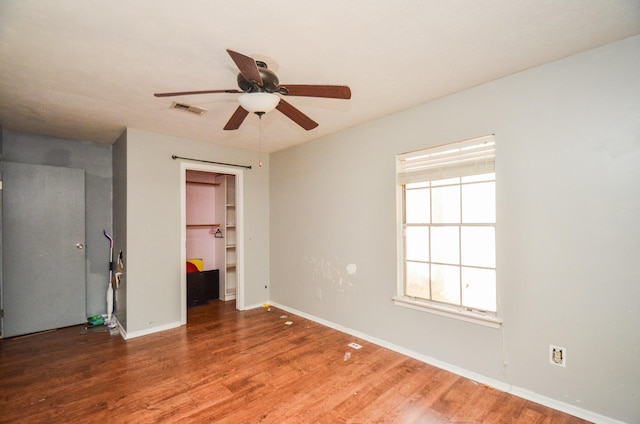 unfurnished bedroom with multiple windows, wood finished floors, and visible vents