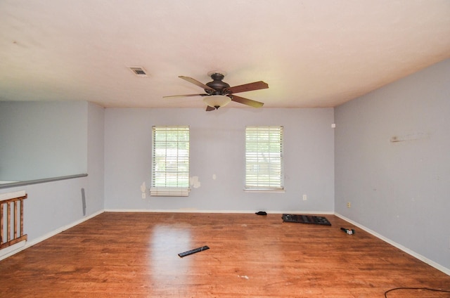 unfurnished room with baseboards, ceiling fan, visible vents, and wood finished floors