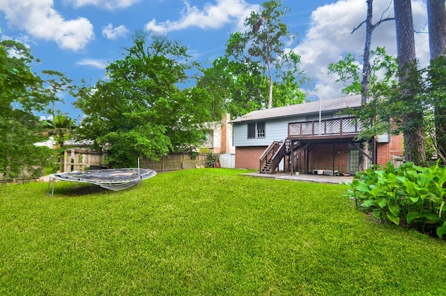 view of yard with stairs, a patio area, a wooden deck, and fence