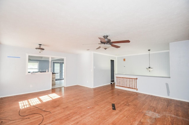 empty room with baseboards, ceiling fan, and wood finished floors