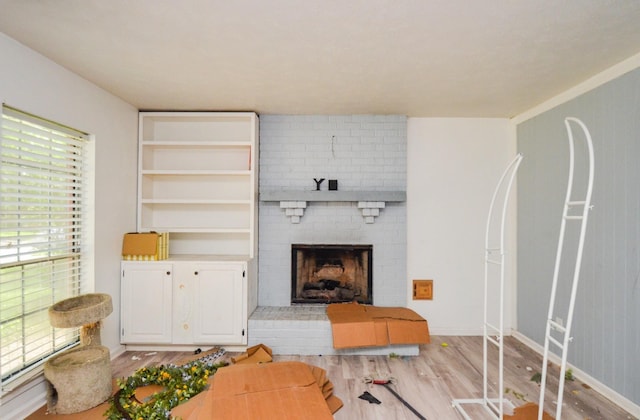 living room with light wood-style floors and a fireplace