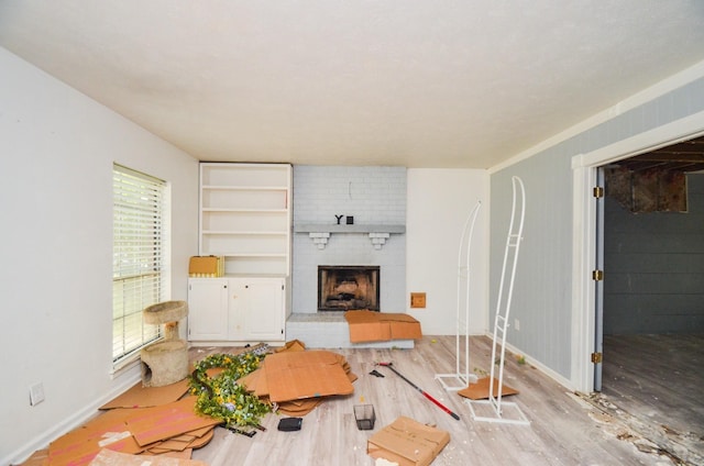 living room with baseboards, a fireplace, and light wood-type flooring