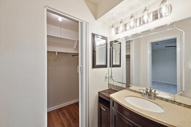 bathroom with vanity, baseboards, and wood finished floors
