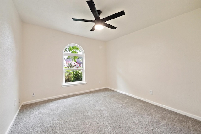 carpeted empty room featuring baseboards and ceiling fan