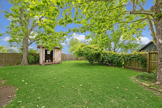 view of yard with a fenced backyard, an outdoor structure, and a shed