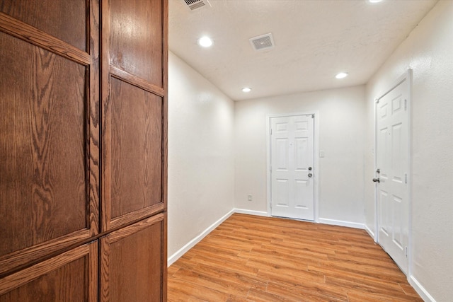 interior space featuring recessed lighting, baseboards, visible vents, and light wood finished floors