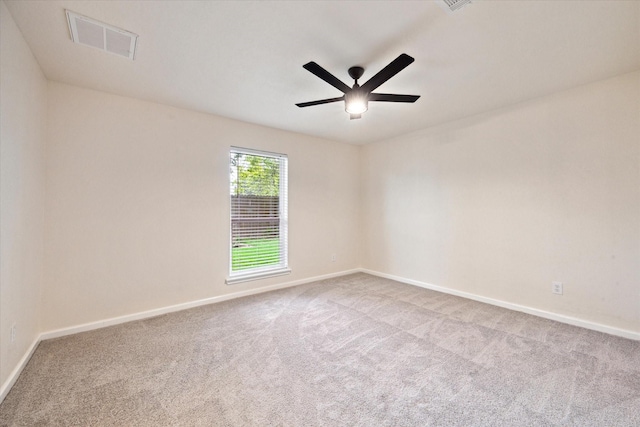 spare room featuring carpet floors, a ceiling fan, baseboards, and visible vents