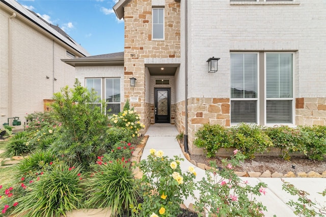 property entrance with stone siding and brick siding