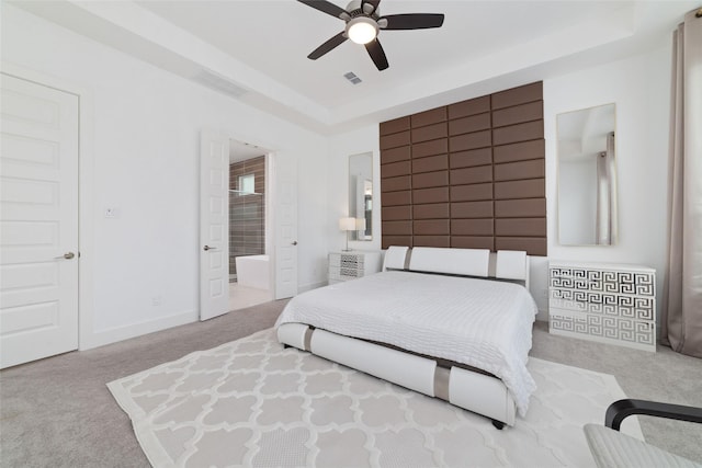 bedroom featuring a raised ceiling, carpet, connected bathroom, and visible vents
