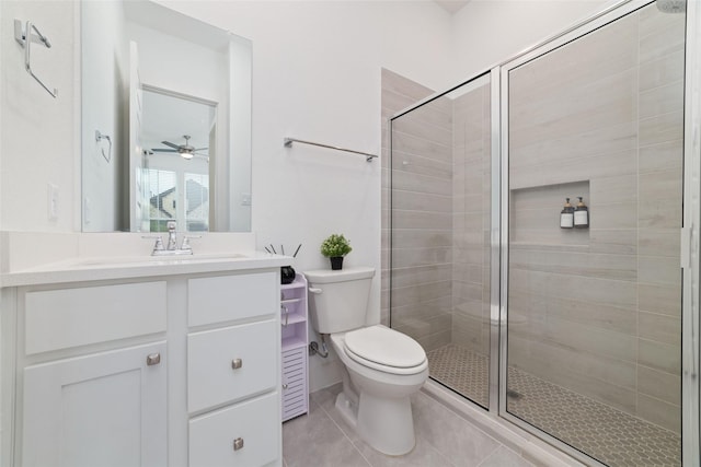 bathroom with ceiling fan, tile patterned flooring, vanity, toilet, and a stall shower