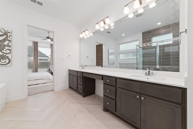 bathroom featuring double vanity, visible vents, a stall shower, a sink, and baseboards