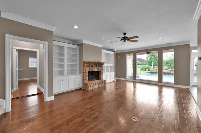 19731 Stone Lake Dr, Tomball, TX 77377 - unfurnished living room with ornamental molding, a ceiling fan, baseboards, a stone fireplace, and wood finished floors