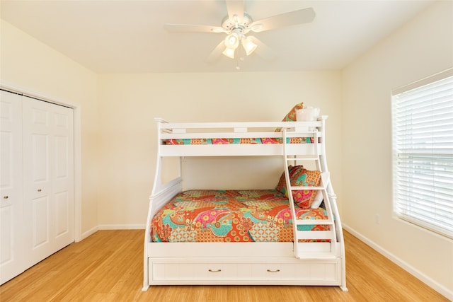 bedroom featuring baseboards, wood finished floors, and a closet