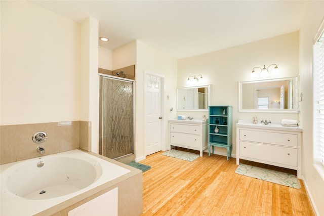 full bath featuring a tub with jets, a shower stall, wood finished floors, and vanity