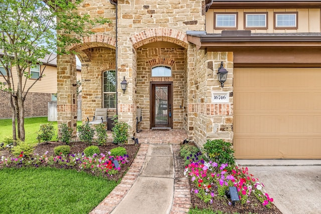property entrance featuring brick siding, stone siding, and a garage