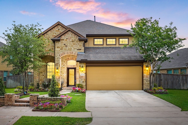 view of front facade with fence, driveway, stone siding, and a garage