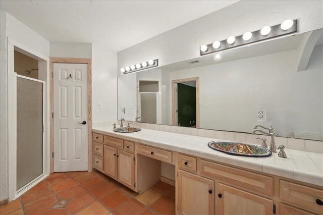 full bath featuring a sink, tile patterned flooring, and a stall shower