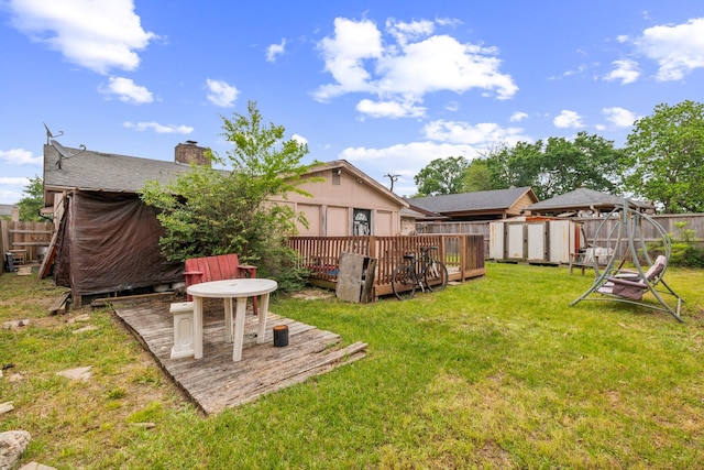 view of yard with a fenced backyard, a storage unit, and a deck