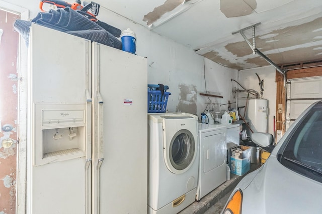 laundry room featuring laundry area, water heater, washing machine and dryer, and a garage
